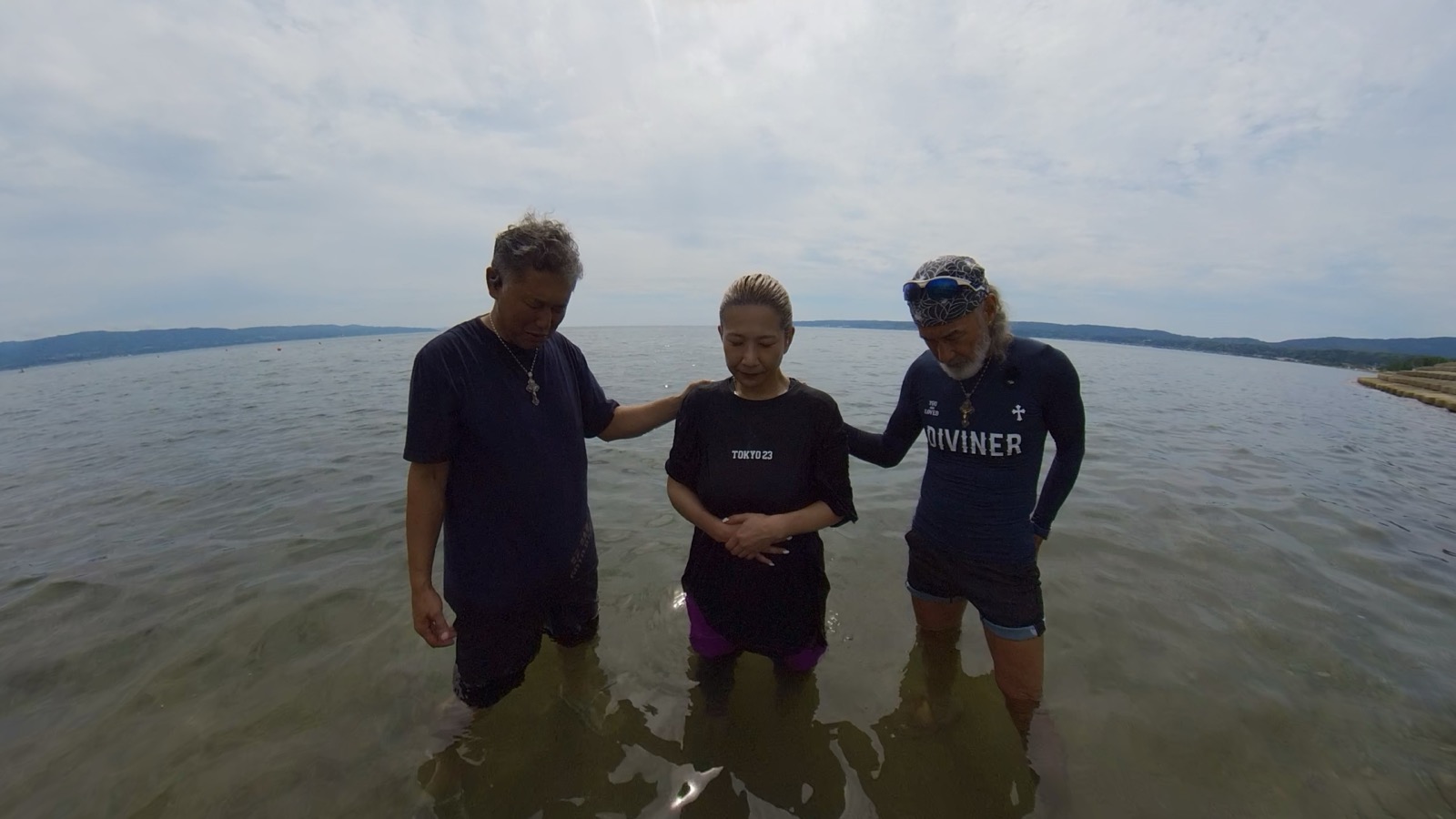 佐渡の海で家族とともに信仰の思いを新たにし洗礼を受ける恵子さん