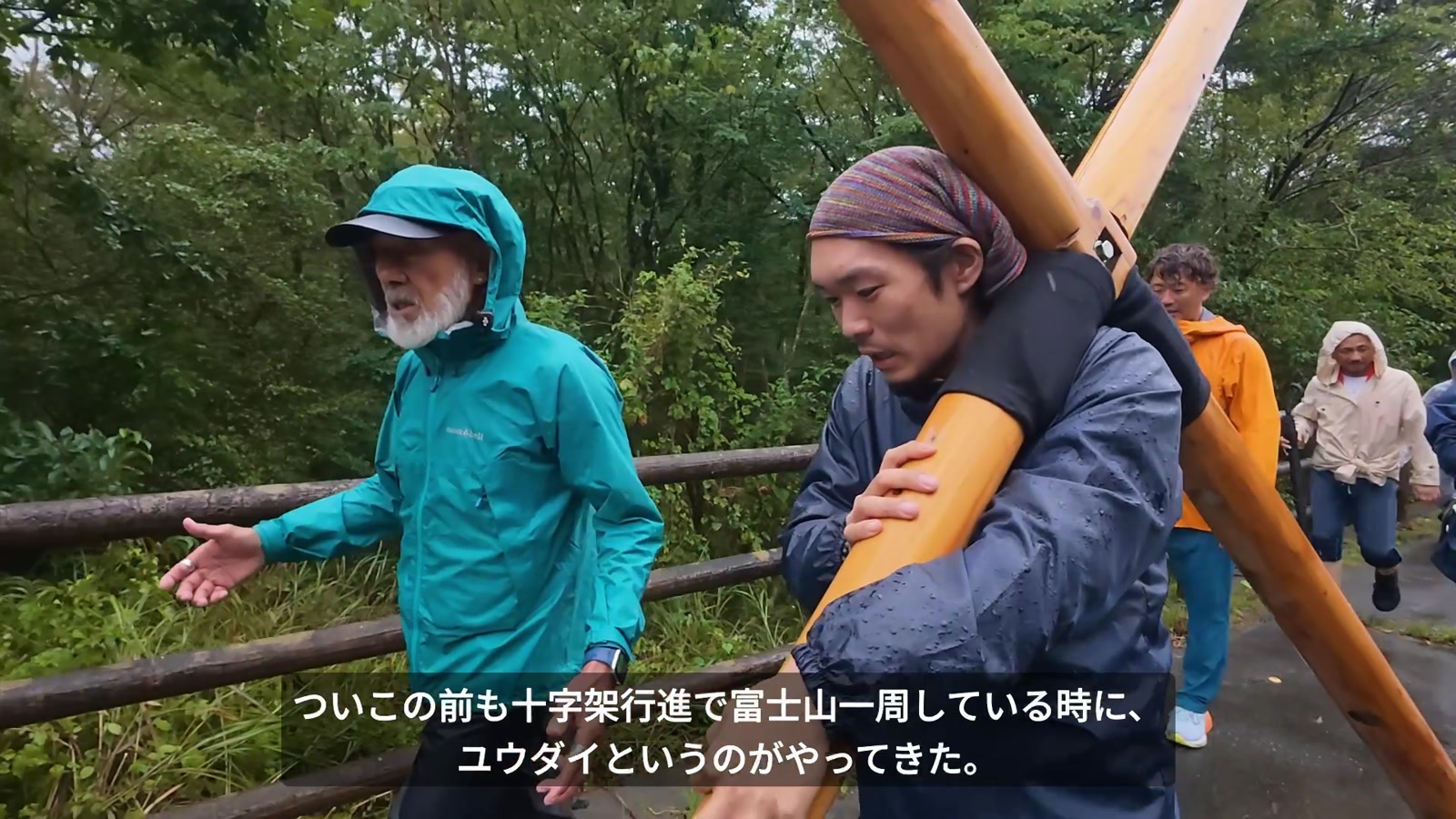 富士山十字架行進で、アーサー先生と共に歩くユウダイさん。