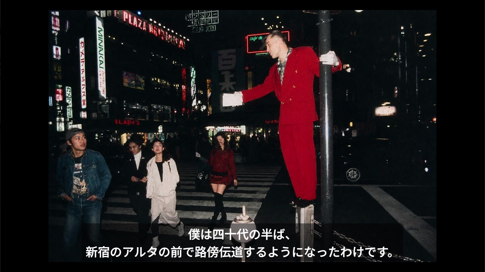 新宿アルタ前で赤いスーツを着て路傍伝道するアーサー先生の写真