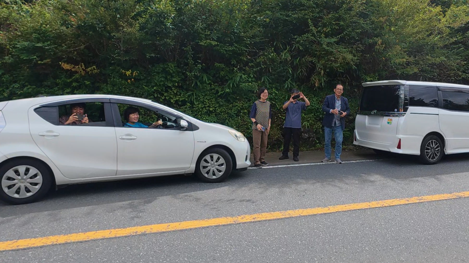 道端と車中から行進に応える韓国から来た人々