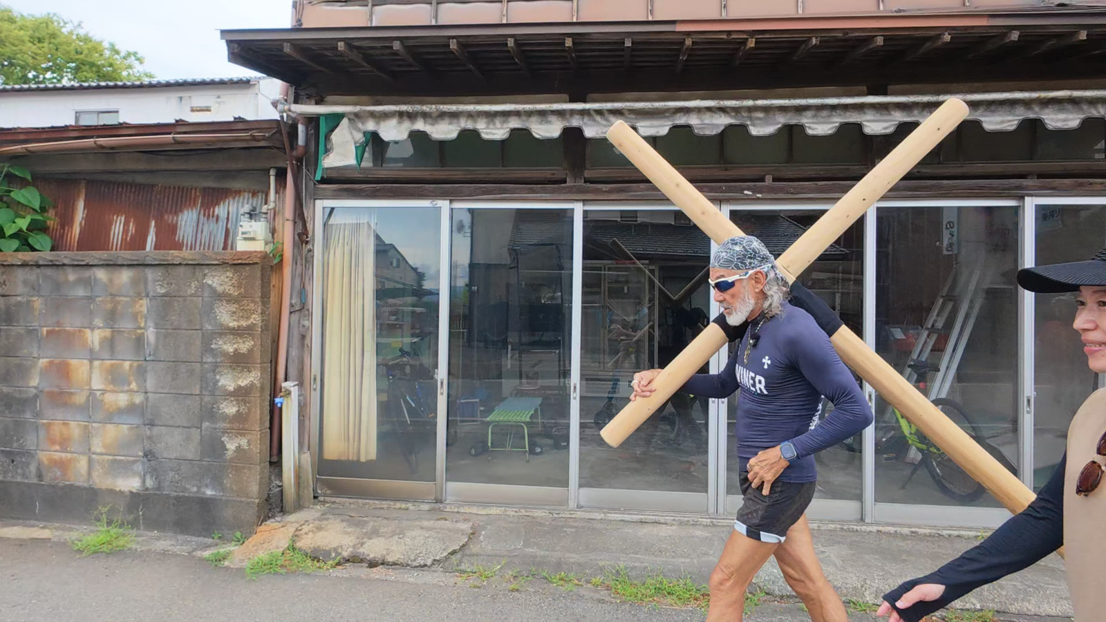 両津の町を十字架とともに歩くアーサー・ホーランド