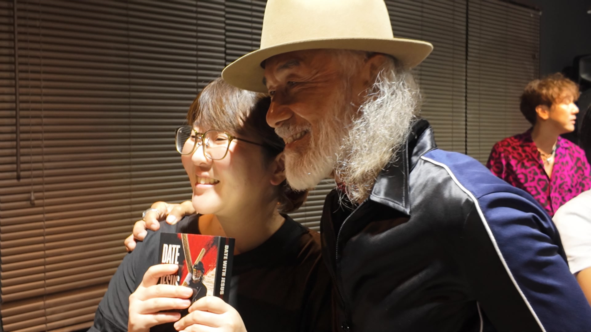 十字架行進を記念してつくられた聖書DATE WITH JESUSを手に、アーサー先生と並ぶ女性