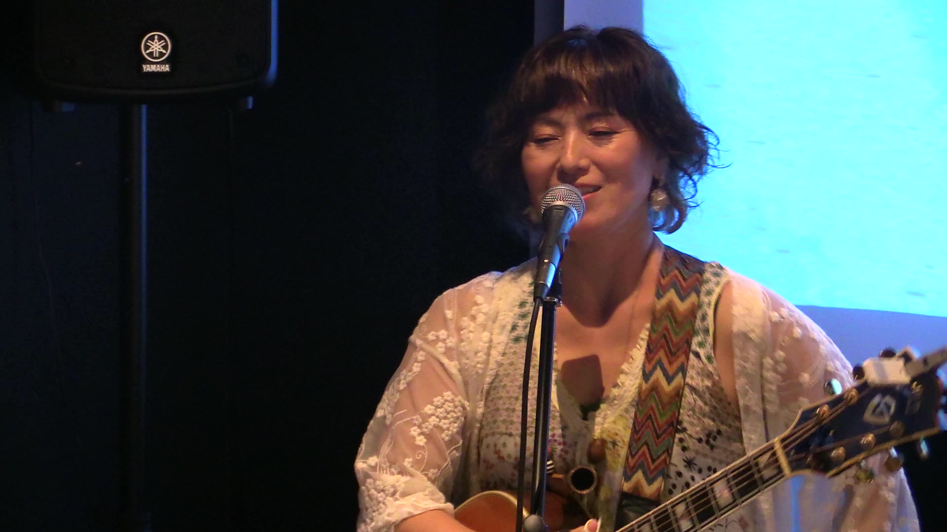 真野シェアベースカフェでギターを手に歌う神山みささん